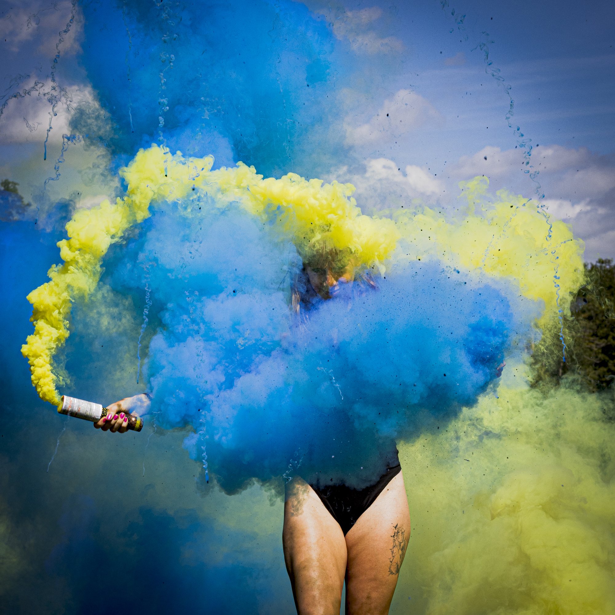 Silhouette dans des fumigènes bleu et jaune en extérieur