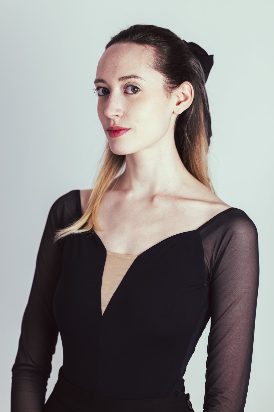 Portrait studio d'une danseuse en robe noire, regard vers l'objectif