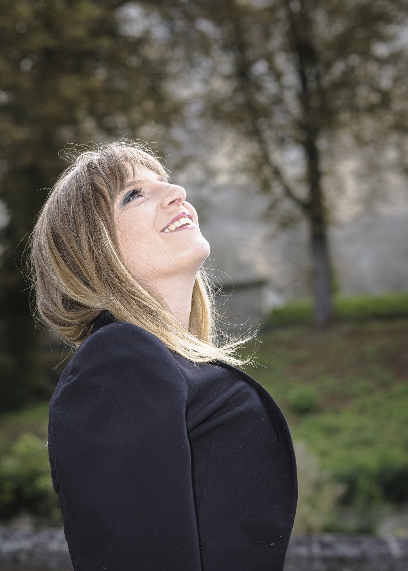 Femme souriante levant les yeux au ciel, séance photo à Pierrefonds
