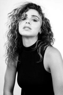 Portrait noir et blanc d'une femme aux cheveux bouclés en débardeur noir