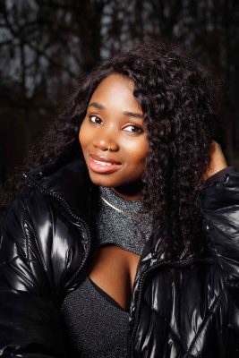 Portrait d'une femme aux cheveux bouclés en doudoune noire