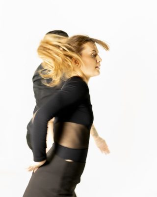 Danseuse blonde en mouvement, cheveux en l'air, photo studio