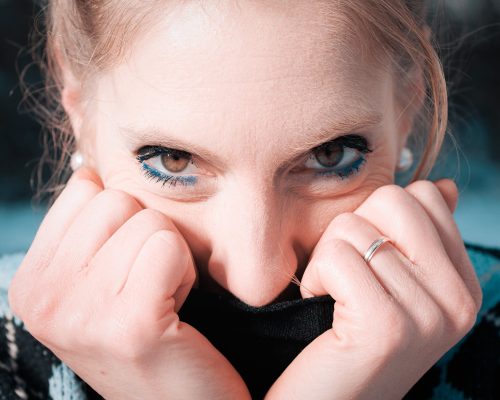 Gros plan sur le regard d'une femme, les mains contre le visage