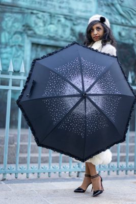 Femme cachée derrière un parapluie étoilé, place Vendôme
