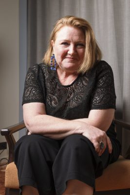 Portrait d'une femme souriante assise dans un fauteuil