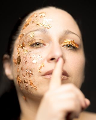 Portrait à la feuille d'or, un doigt posé sur les lèvres