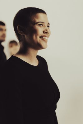 Portrait souriant d'une femme aux cheveux courts en tenue noire